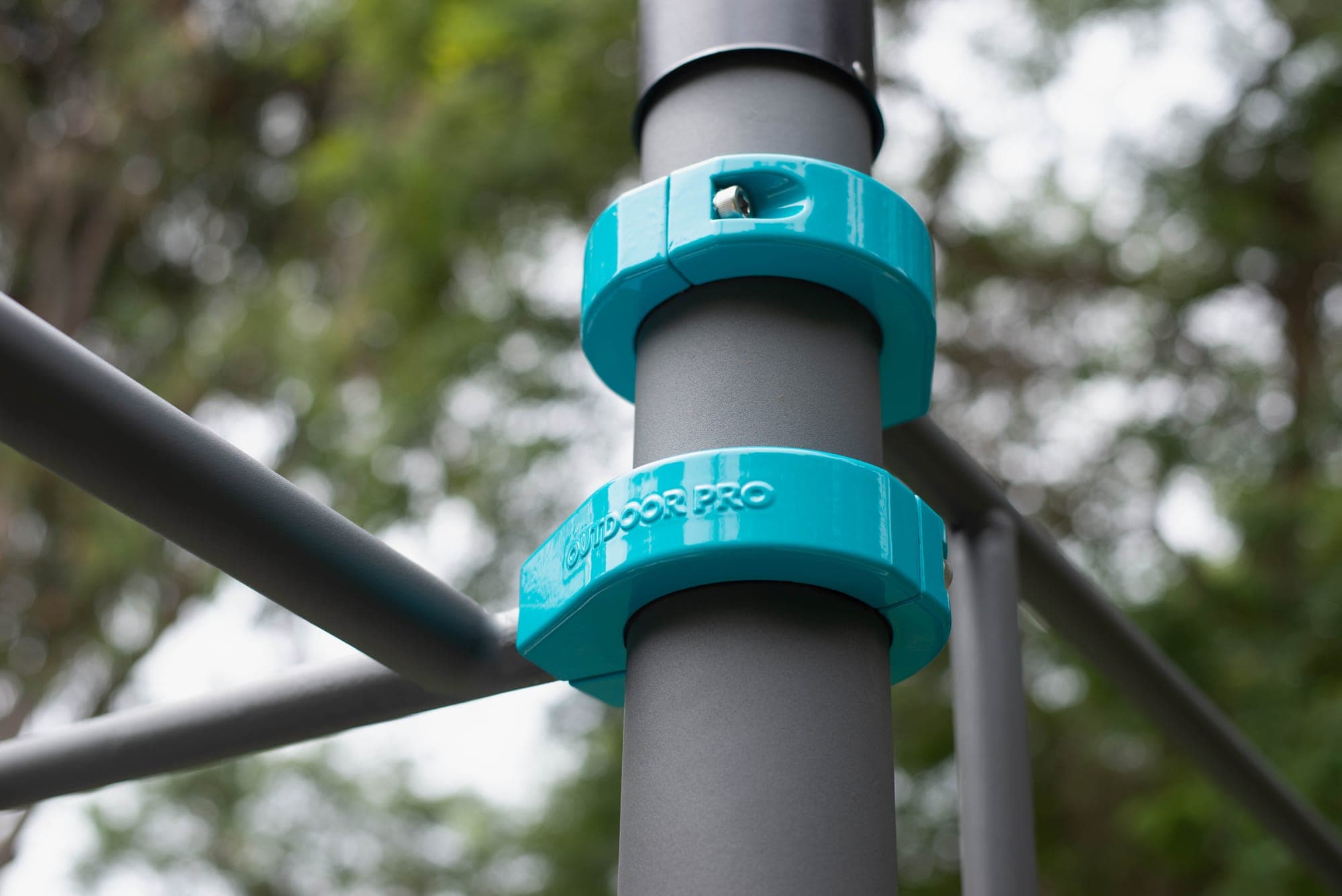 Abrazadera OUTDOOR PRO turquesa sobre poste gris, vista de detalle