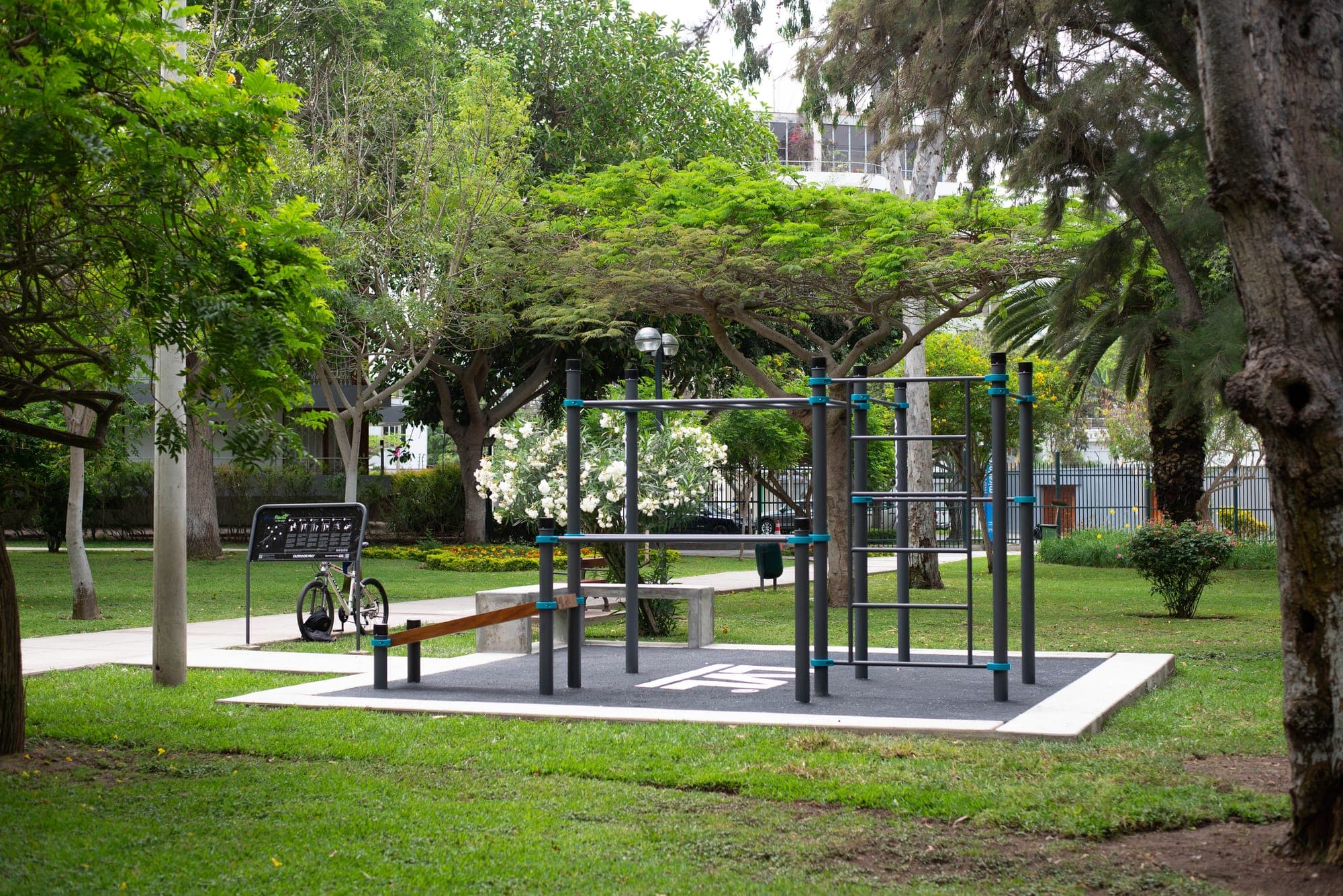 Parque de calistenia sobre piso de caucho bajo los árboles