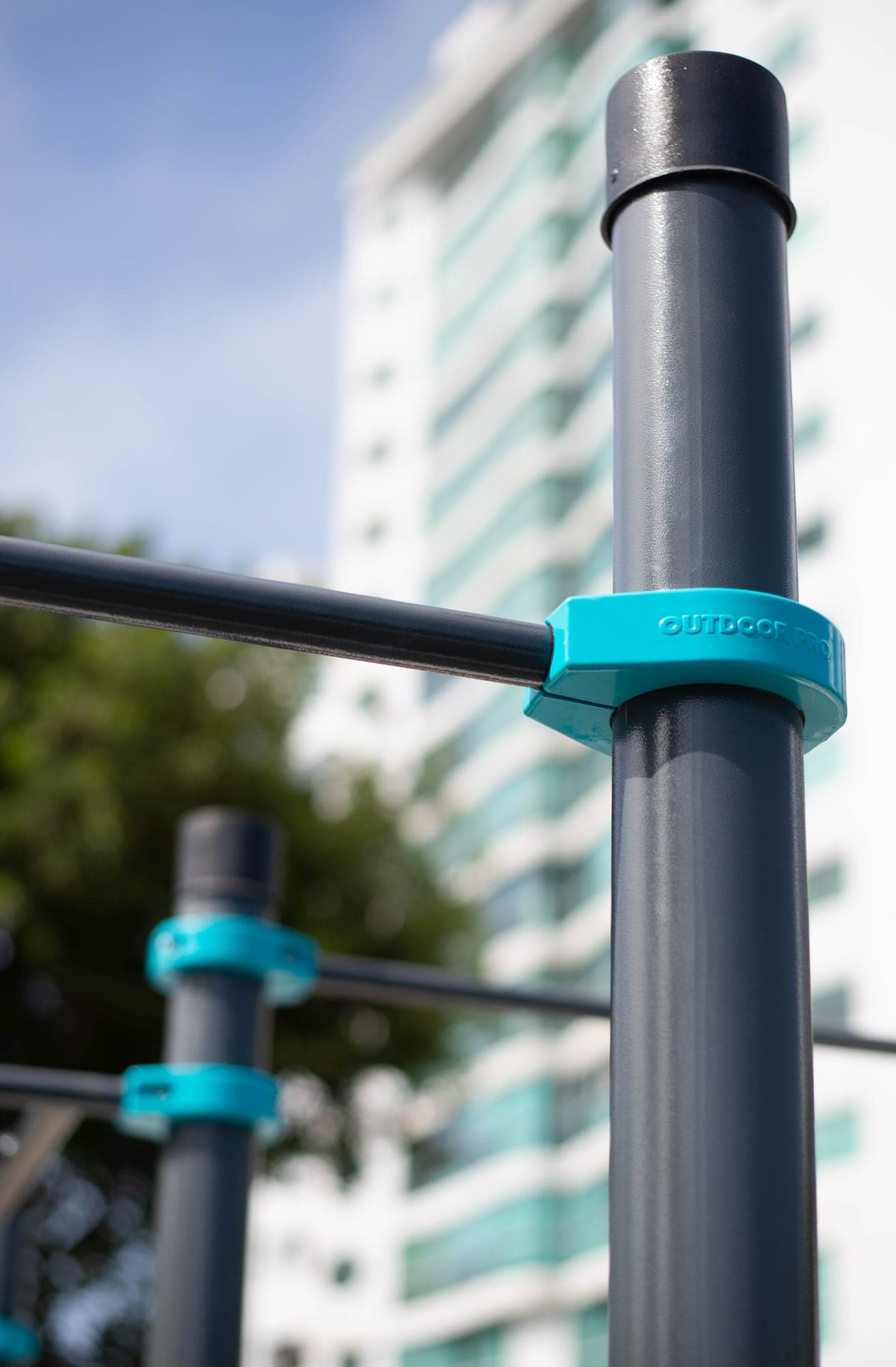 Poste con abrazadera OUTDOOR PRO frente a un edificio