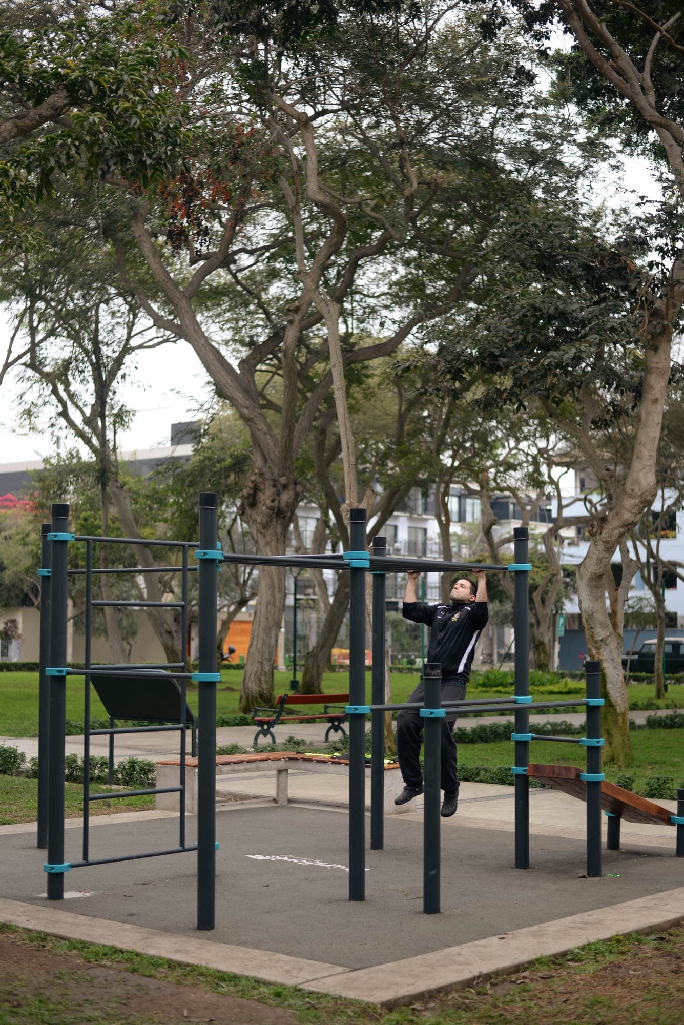Usuario haciendo dominadas en el módulo de calistenia de un parque